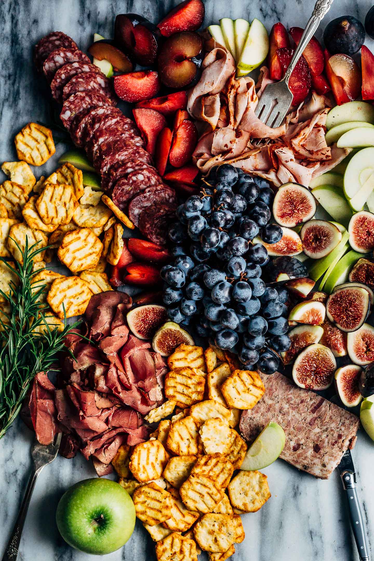 A creative charcuterie graze board that doubles as an eye-catching centerpiece for autumn gatherings. Featuring an assortment of meats, fresh fall fruit, and cheese crisps this charcuterie graze board comes together in minutes.