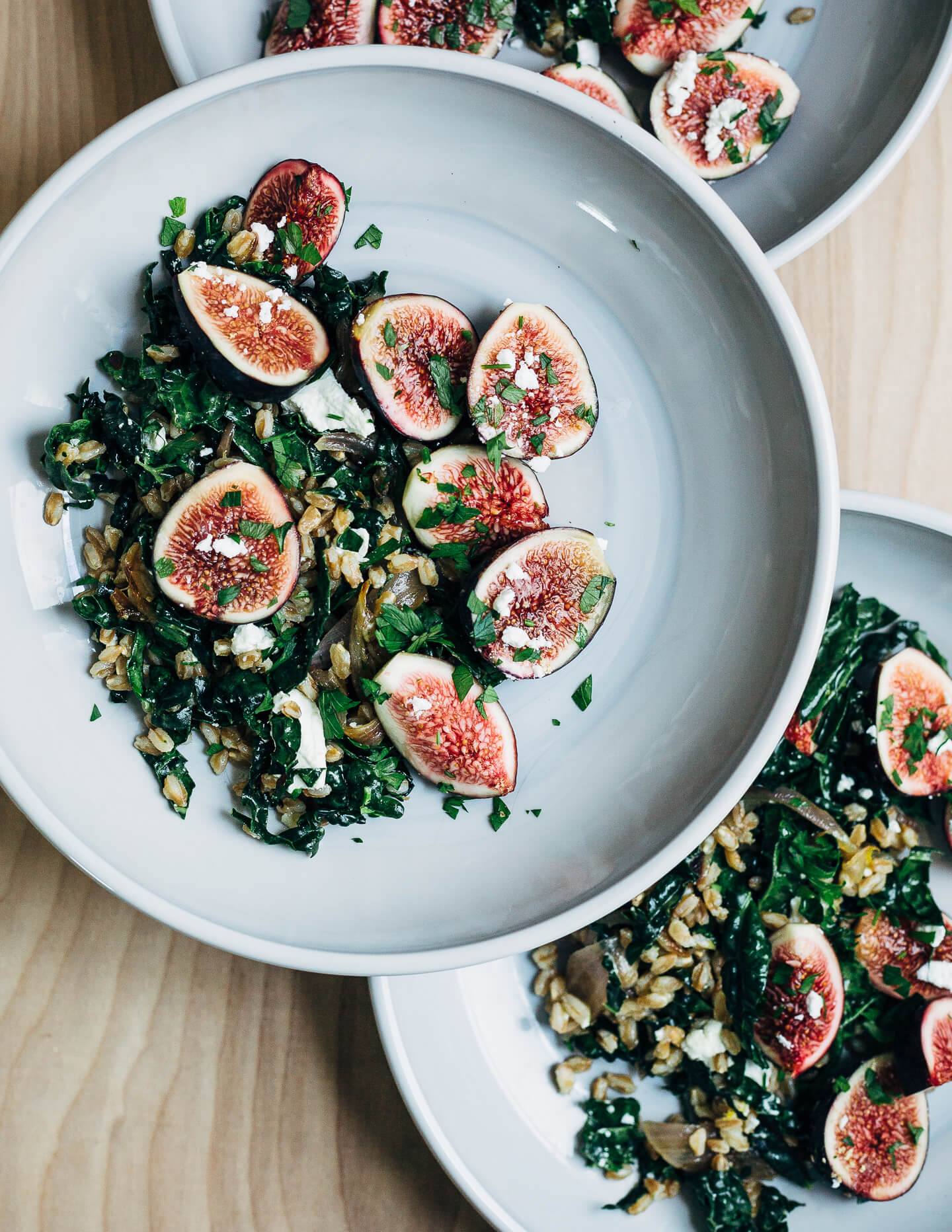 This nutty toasted farro salad features al dente farro tossed with massaged kale and ruby-hued fresh figs topped with creamy goat cheese crumbles and fresh parsley.