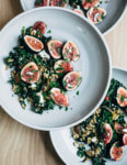 A nutty toasted farro salad featuring al dente farro tossed with massaged kale, ruby-hued fresh figs, creamy goat cheese crumbles, and fresh parsley.