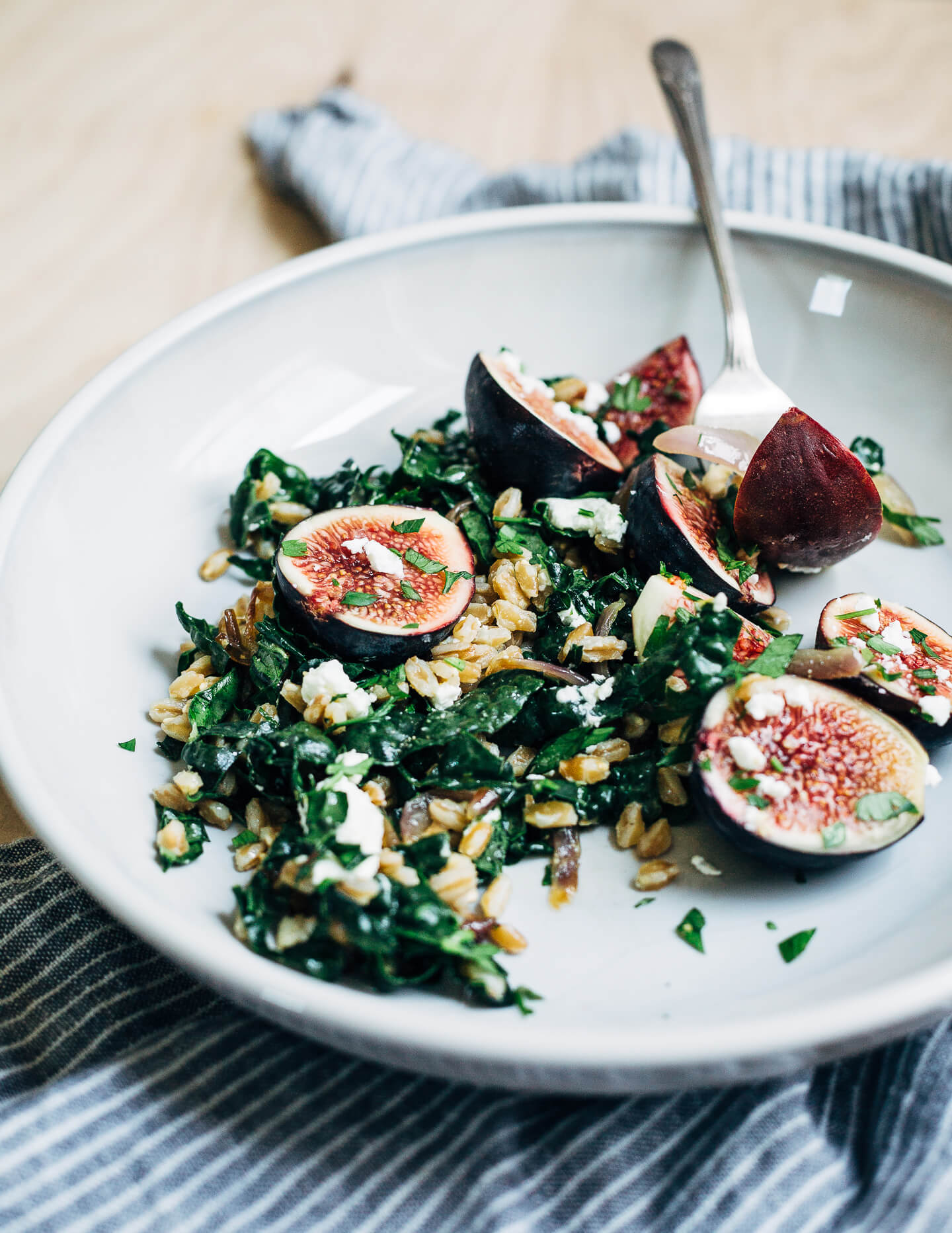 This nutty toasted farro salad features al dente farro tossed with massaged kale and ruby-hued fresh figs topped with creamy goat cheese crumbles and fresh parsley.