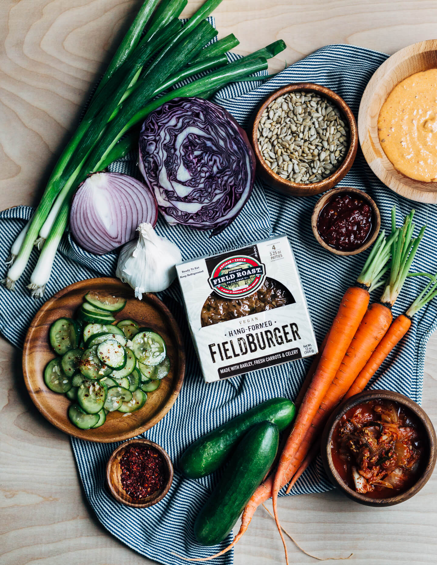 A fresh spin on the traditional tailgating party featuring plant-based kimchi burgers topped with grilled green onions and a spicy gochujang sunflower spread.