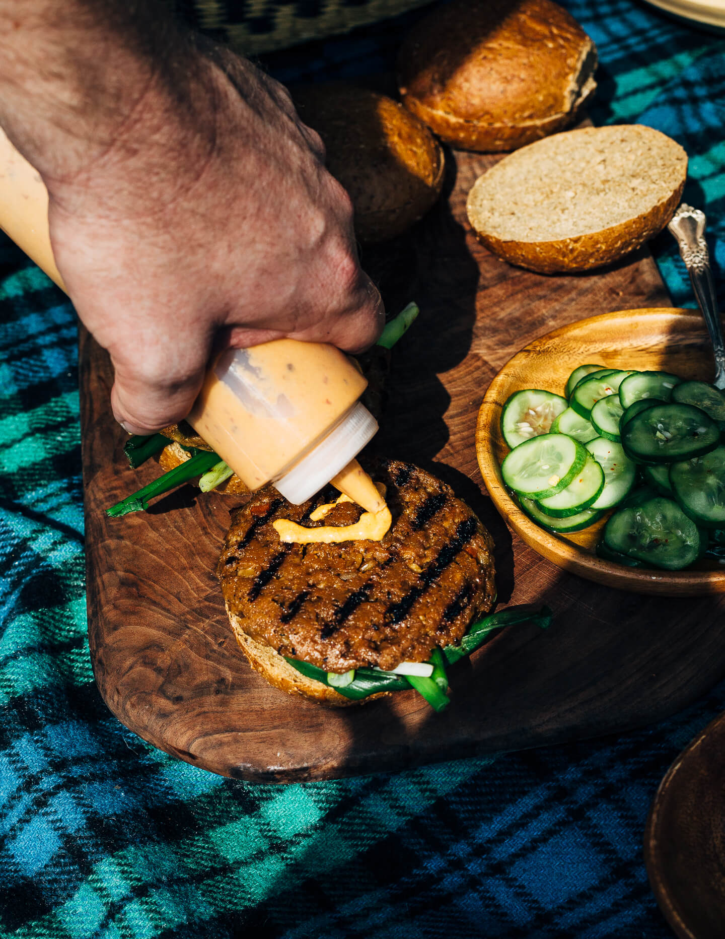 A fresh spin on the traditional tailgating party featuring plant-based kimchi burgers topped with grilled green onions and a spicy gochujang sunflower spread.