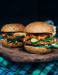 A fresh spin on the traditional tailgating party featuring plant-based kimchi burgers topped with grilled green onions and a spicy gochujang sunflower spread.