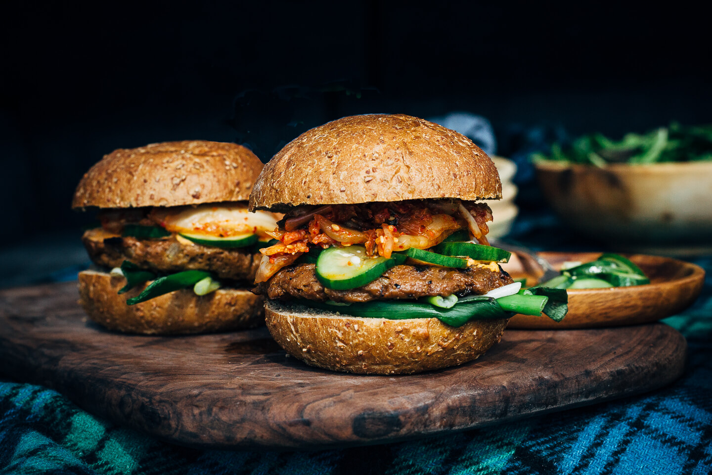 A fresh spin on the traditional tailgating party featuring plant-based kimchi burgers topped with grilled green onions and a spicy gochujang sunflower spread.