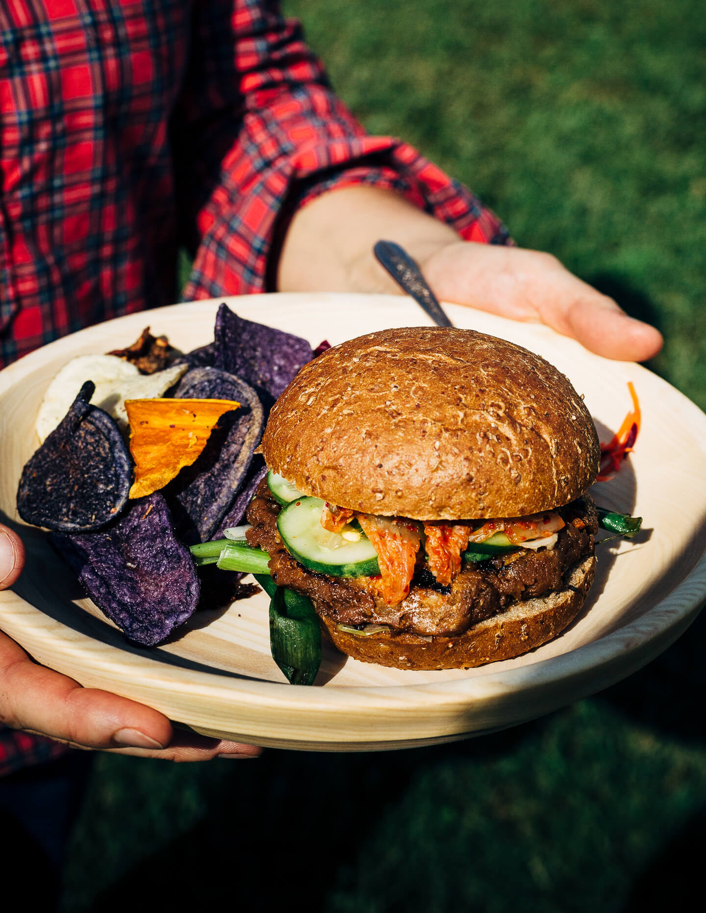 A fresh spin on the traditional tailgating party featuring plant-based kimchi burgers topped with grilled green onions and a spicy gochujang sunflower spread.