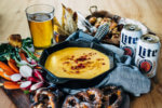 A simple, classic beer cheese recipe served alongside crispy fried cauliflower bites, toast soldiers, and crunchy dark pretzels.