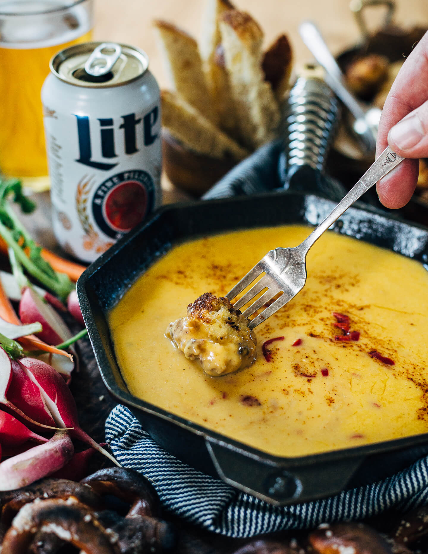 A simple, classic beer cheese recipe served alongside crispy fried cauliflower bites, toast soldiers, and crunchy dark pretzels.