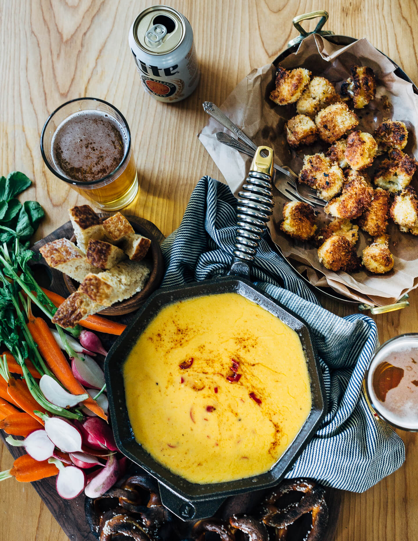 A simple, classic beer cheese recipe served alongside crispy fried cauliflower bites, toast soldiers, and crunchy dark pretzels.