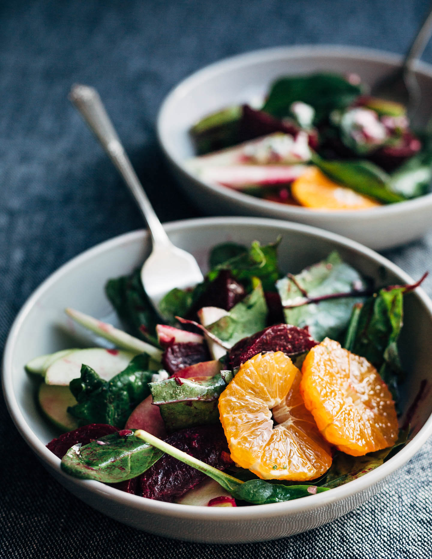 A bright and crunchy green apple and beet salad recipe featuring sliced green apples, marinated beets tossed with red wine vinegar and shallot, beet greens, spinach, herbed goat cheese crumbles, and a simple vinaigrette. 