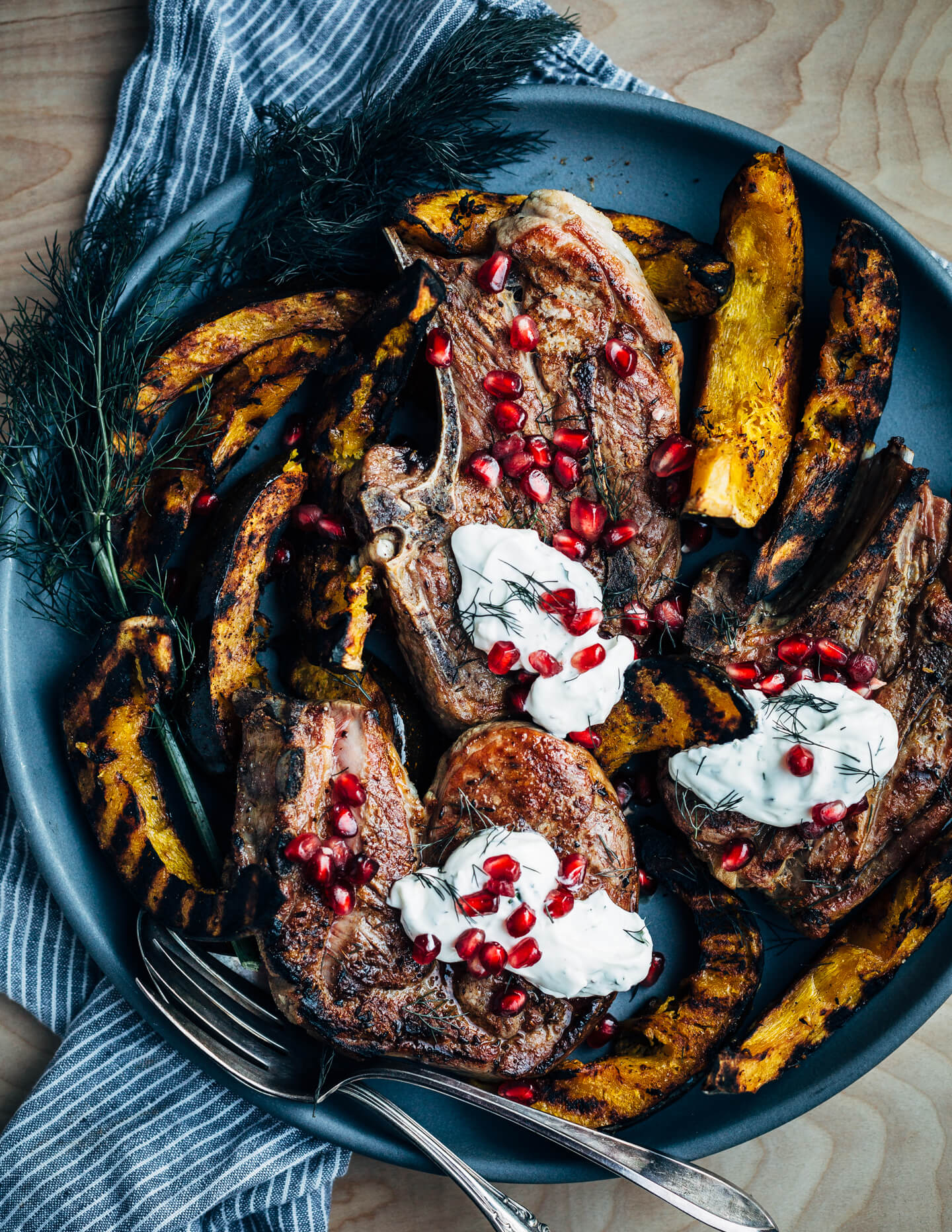 Add a pop of char and smoke to your Thanksgiving feast with this recipe for cumin-rubbed grilled lamb chops, grilled acorn squash wedges, dill and fennel tzatziki, and pomegranate arils. 