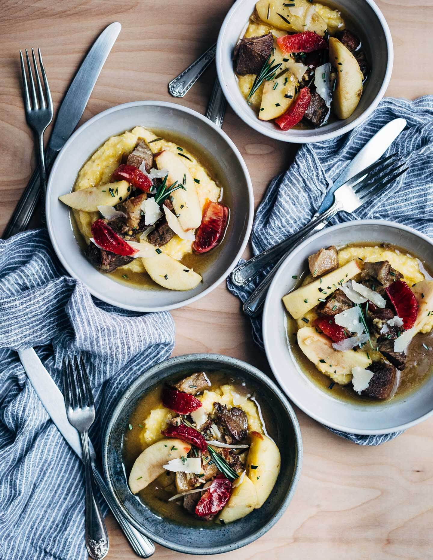 A simple and savory wintry stew featuring braised pork with apples, rosemary, chilies, and citrus served over polenta. 