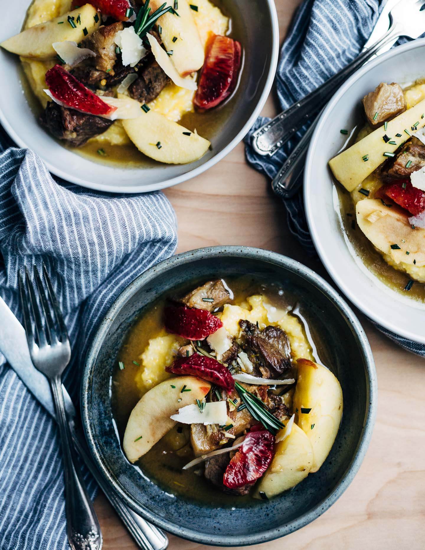 A simple and savory wintry stew featuring braised pork with apples, rosemary, chilies, and citrus served over polenta. 