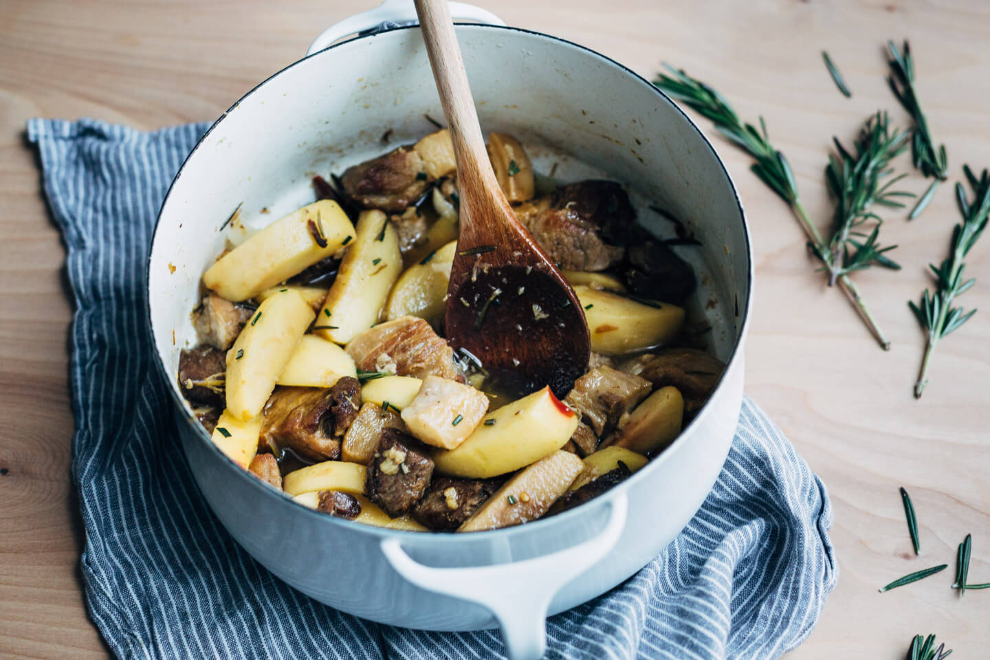 A simple and savory wintry stew featuring braised pork with apples, rosemary, chilies, and citrus served over polenta. 