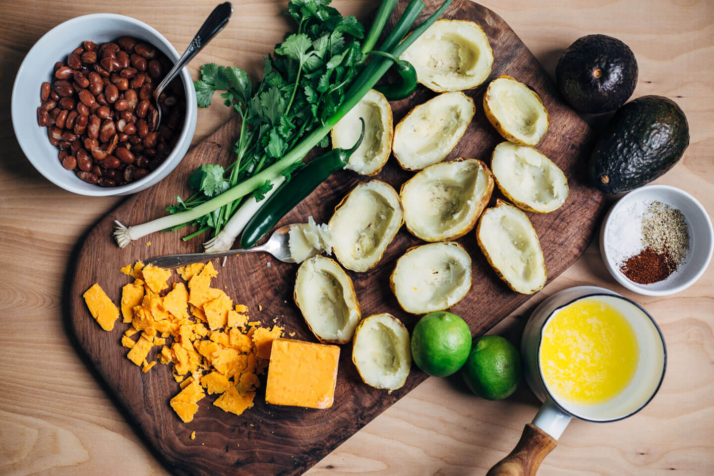 These vegetarian Tex-Mex potato skins are loaded with pinto beans, cheddar, green onions, herbs, jalapeños, avocado, and lime crema.