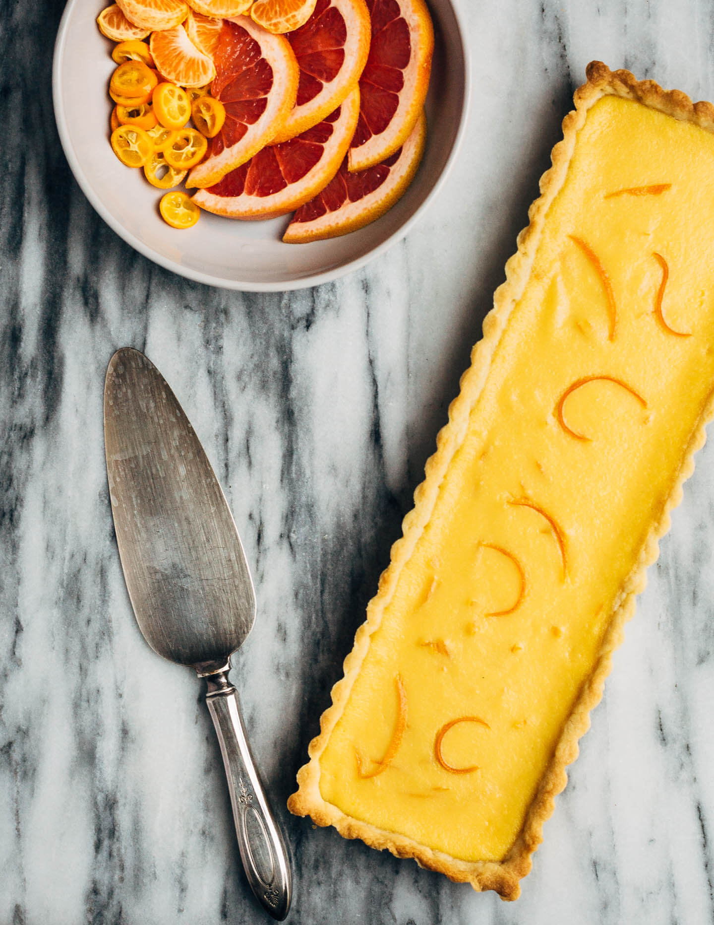 A bright and creamy grapefruit curd tart baked up in a classic pâte sucrée crust that's perfect for celebratory winter meals.