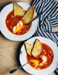 A simple tomato soup with poached eggs that can be as easy or as complex as you'd like. This one has harissa for heat and a little crunch from pickled onions. Golden, garlicky croutons are extra, but so delicious.