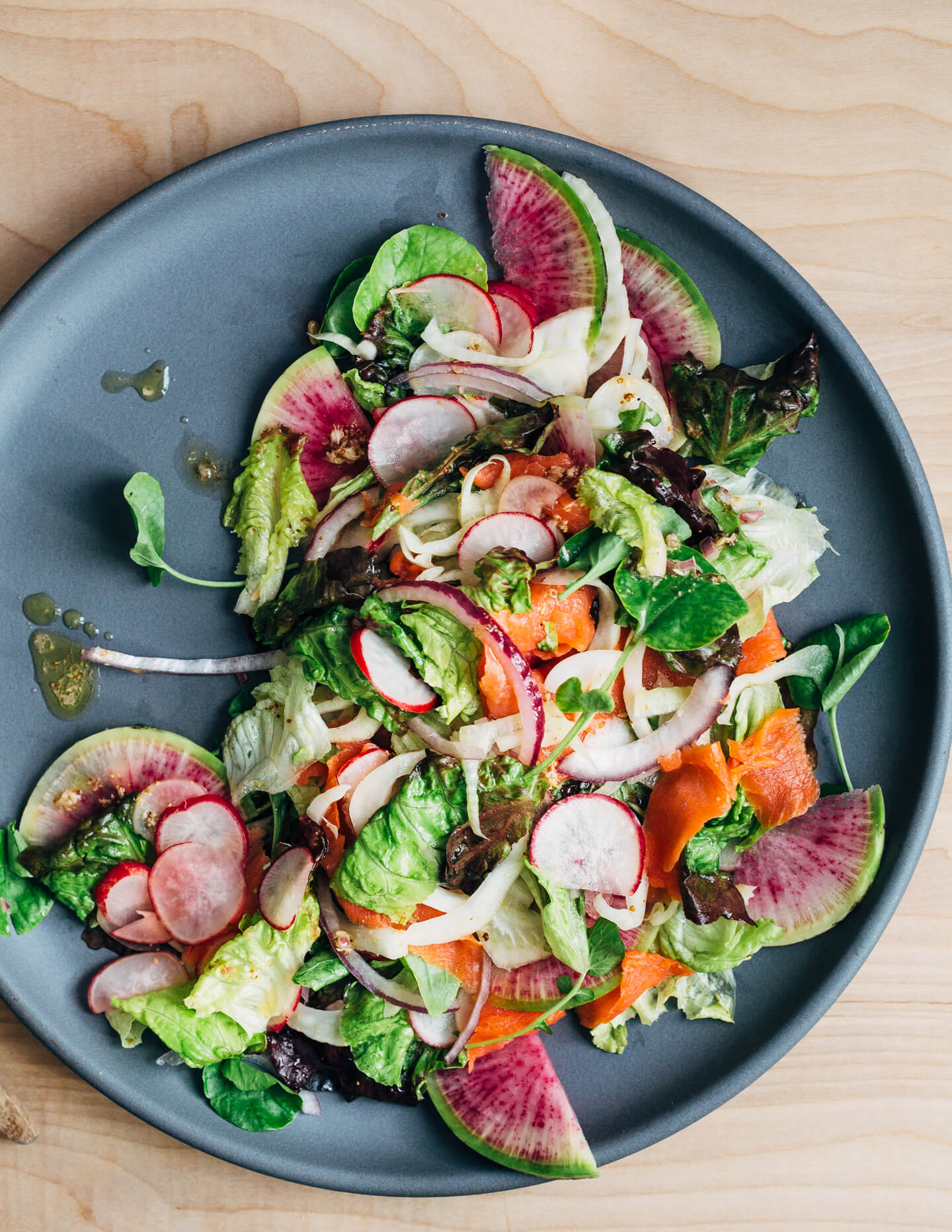 A colorful smoked salmon salad to herald spring! Smoked salmon and delicate lettuces are layered with thinly sliced fennel, radish, and red onion, and tossed with an assertive Dijon and horseradish vinaigrette. 