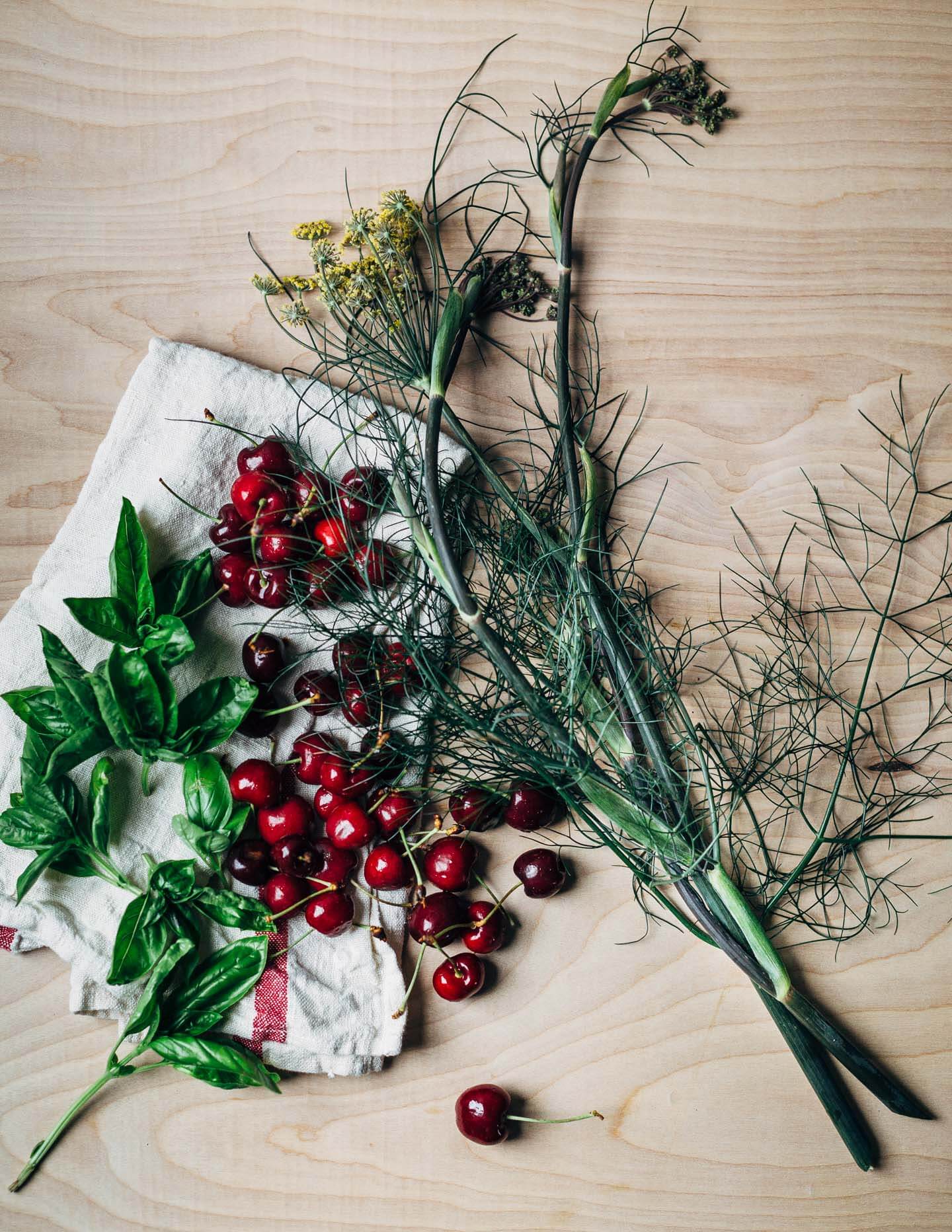 Flowering fennel fronds, sweet Bing cherries, and fresh basil leaves. 