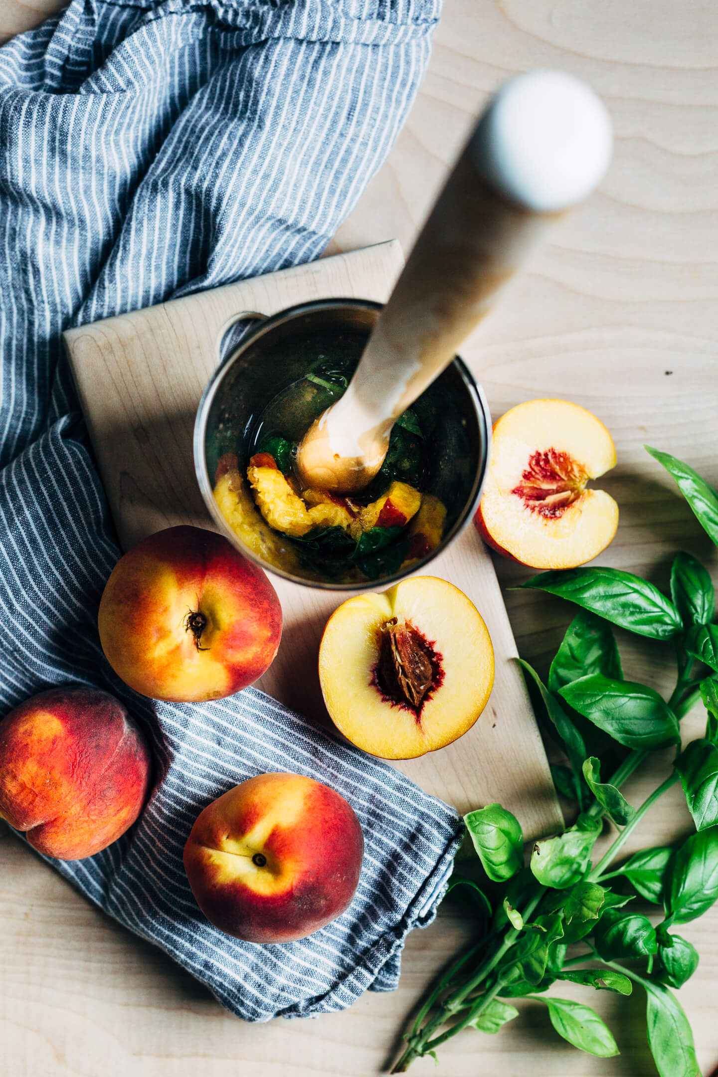 Fresh summer peaches muddled with basil leaves make for a delicious peach bourbon smash. 
