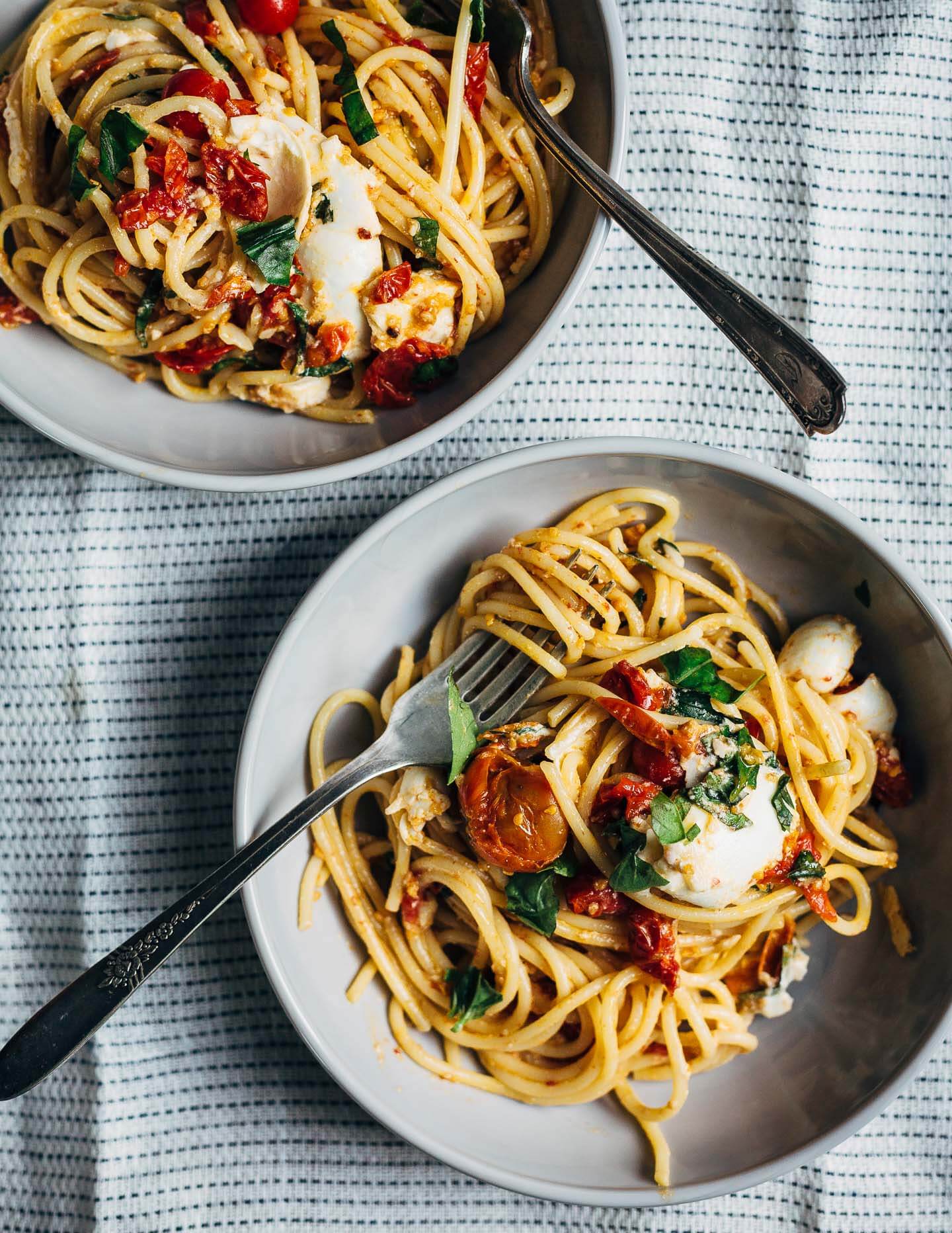 Swirls of al dente spaghetti topped with roasted cherry tomato marinara, burrata, and fresh herbs. 