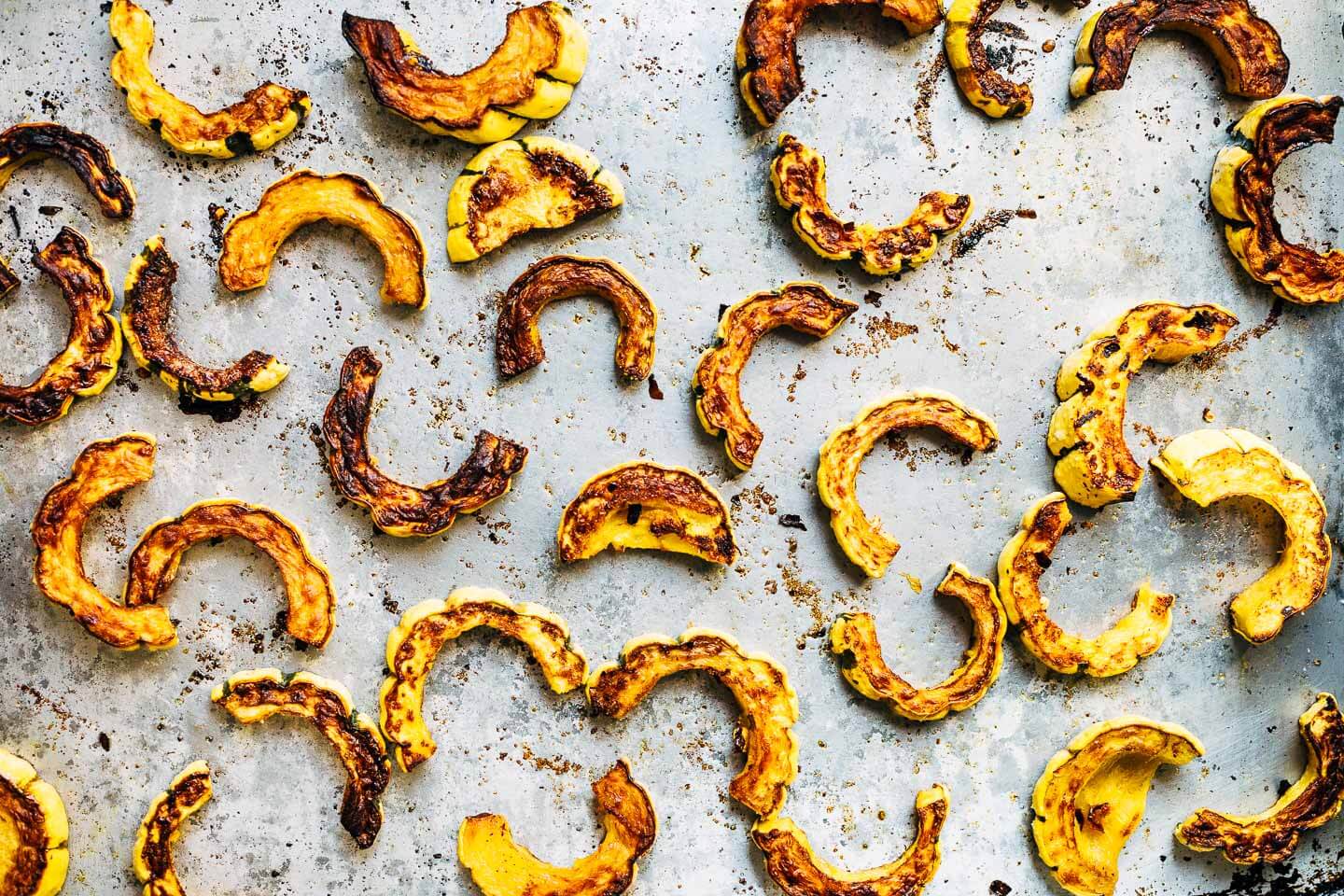 Roasted delicata squash on a sheet pan.