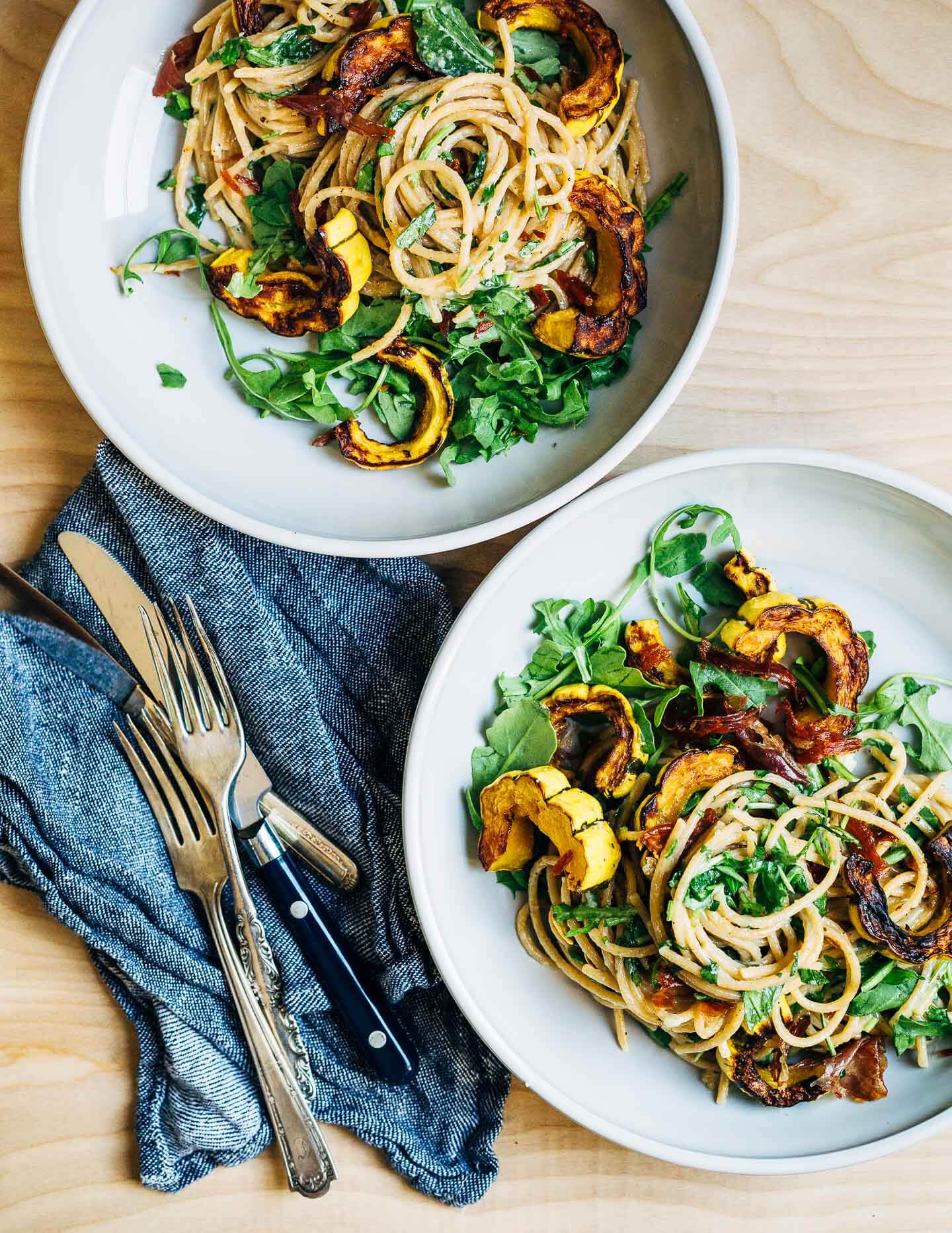 Up your pasta night game with this recipe for al dente whole wheat spaghetti tossed with creamy Parmesan sauce, roasted delicata squash, crispy speck, and handfuls of arugula and fresh herbs. Copious amounts of fresh ground black pepper are optional.