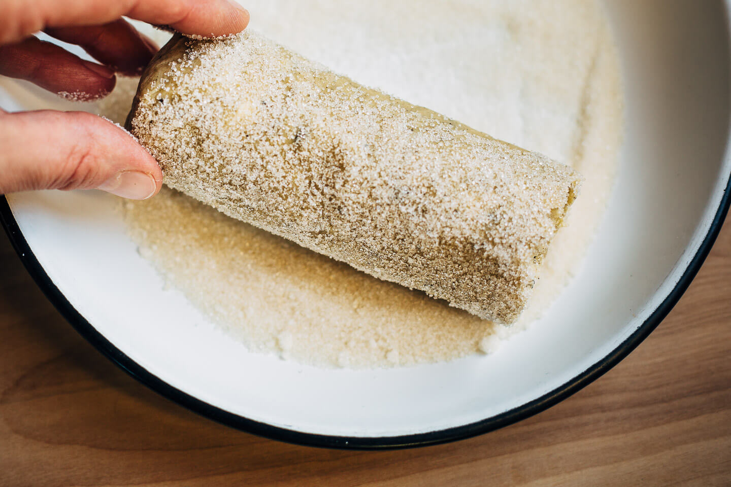 Rolling Earl Grey sablé dough in cane sugar. 