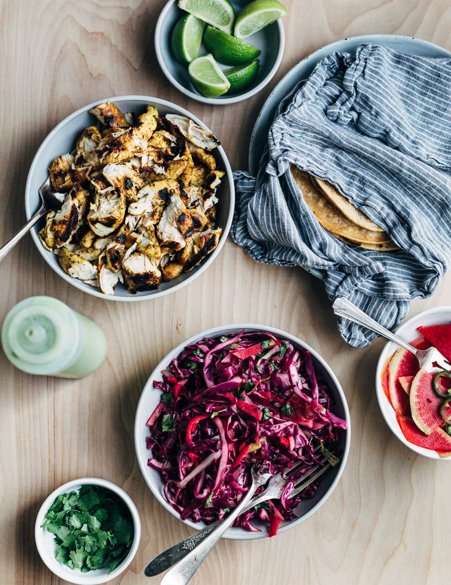 A spread featuring grilled chicken taco meat and red cabbage slaw. 