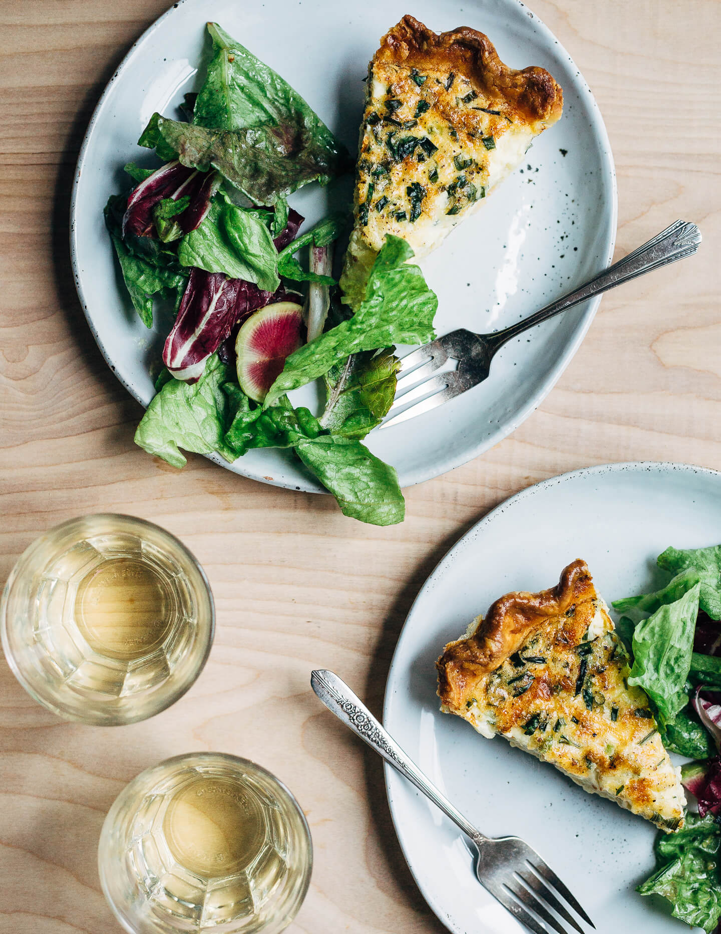 Cheddar quiche slices served with a lemony green salad. 