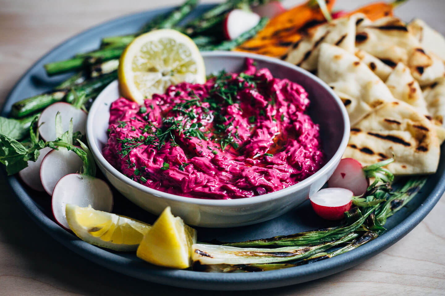 Super vibrant vegan beet tzatziki served with grilled asparagus, spring carrots, and naan. 