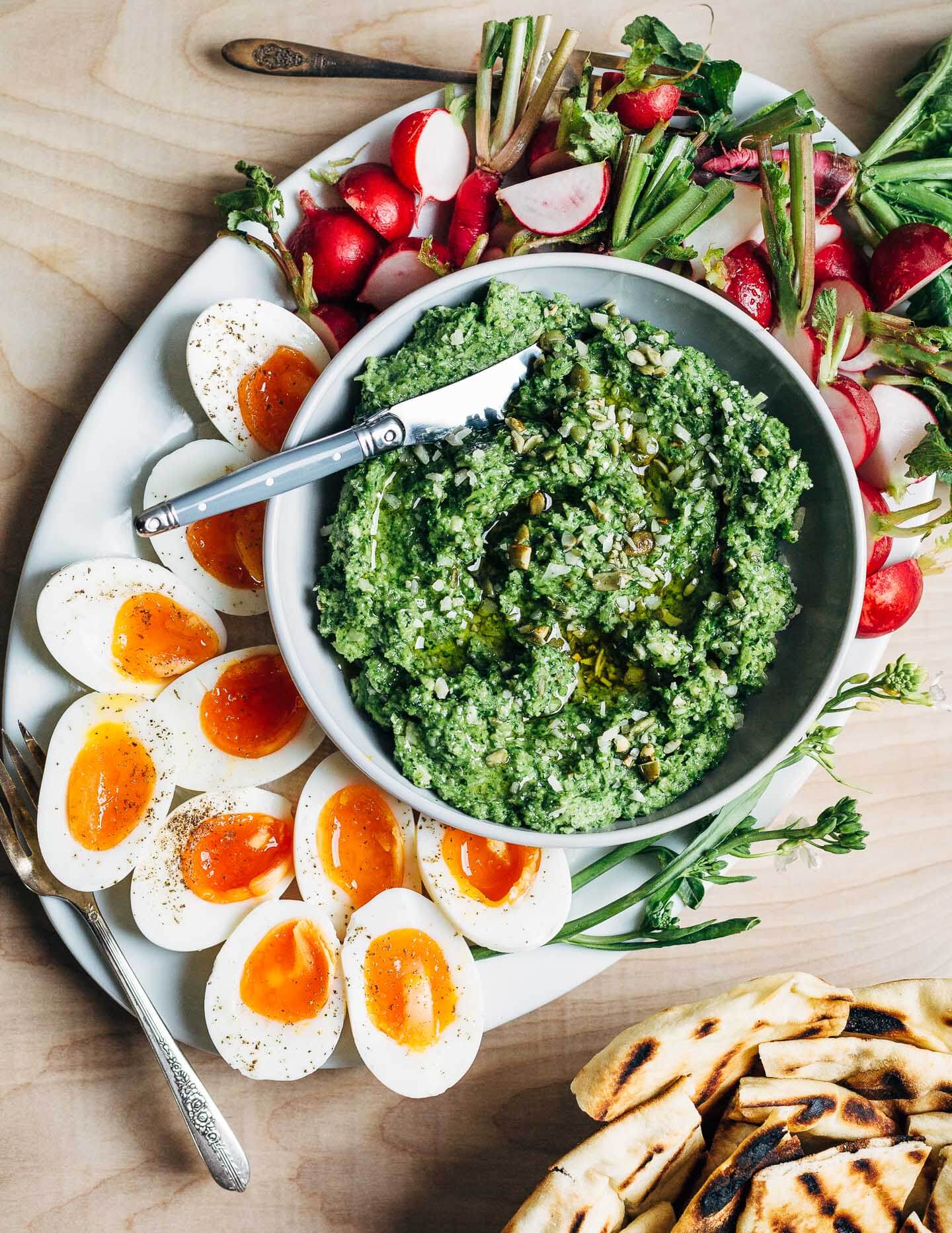 A versatile recipe for green garlic pesto that comes straight from my spring garden. My green garlic pesto is made with radish greens and pepitas, and served alongside jammy steamed eggs and lemony sliced radishes.