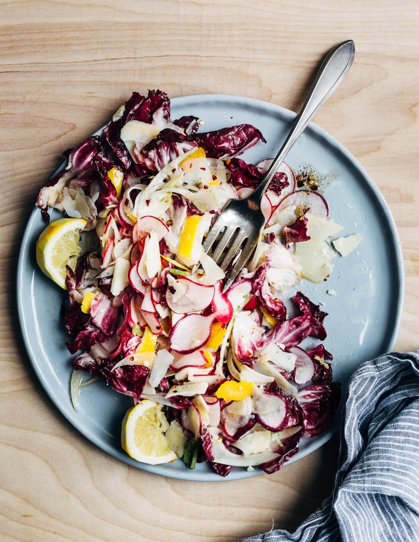 A punchy shaved radish and Parmesan salad featuring shaved radishes, fennel, and Parmesan tossed with radicchio, lemon zest, spicy olive oil, and nutty fried garlic. 