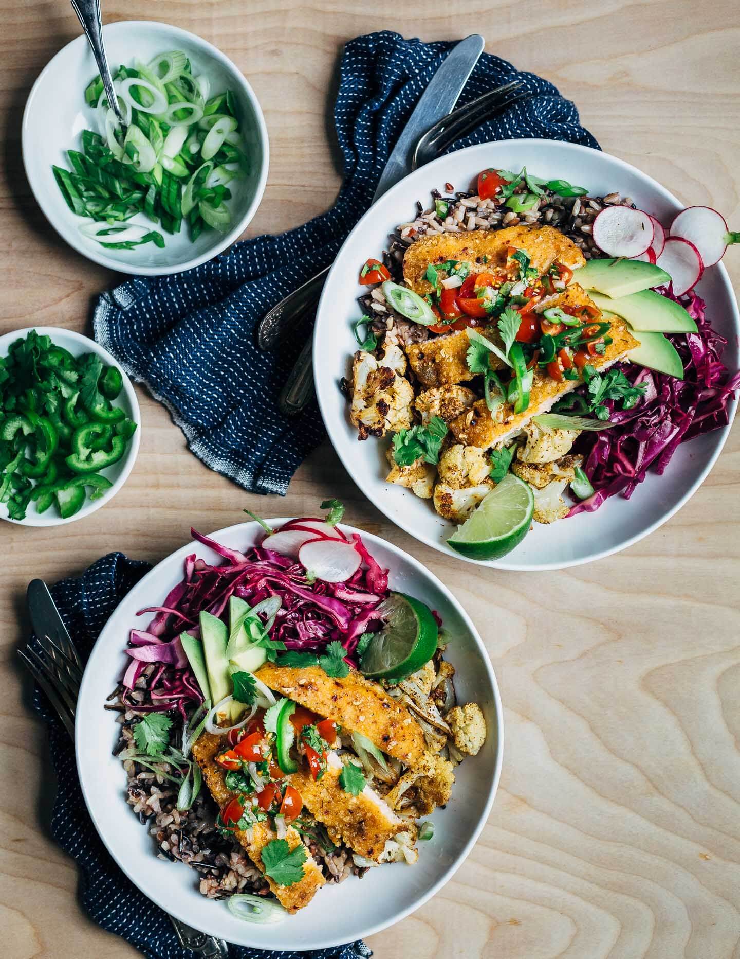 Vibrant honey-chipotle salmon taco bowls with wild rice, roasted cauliflower, cilantro, and a fresh cherry tomato and jalapeño relish. These simple salmon taco bowls are perfect for a quick and easy weeknight meal.