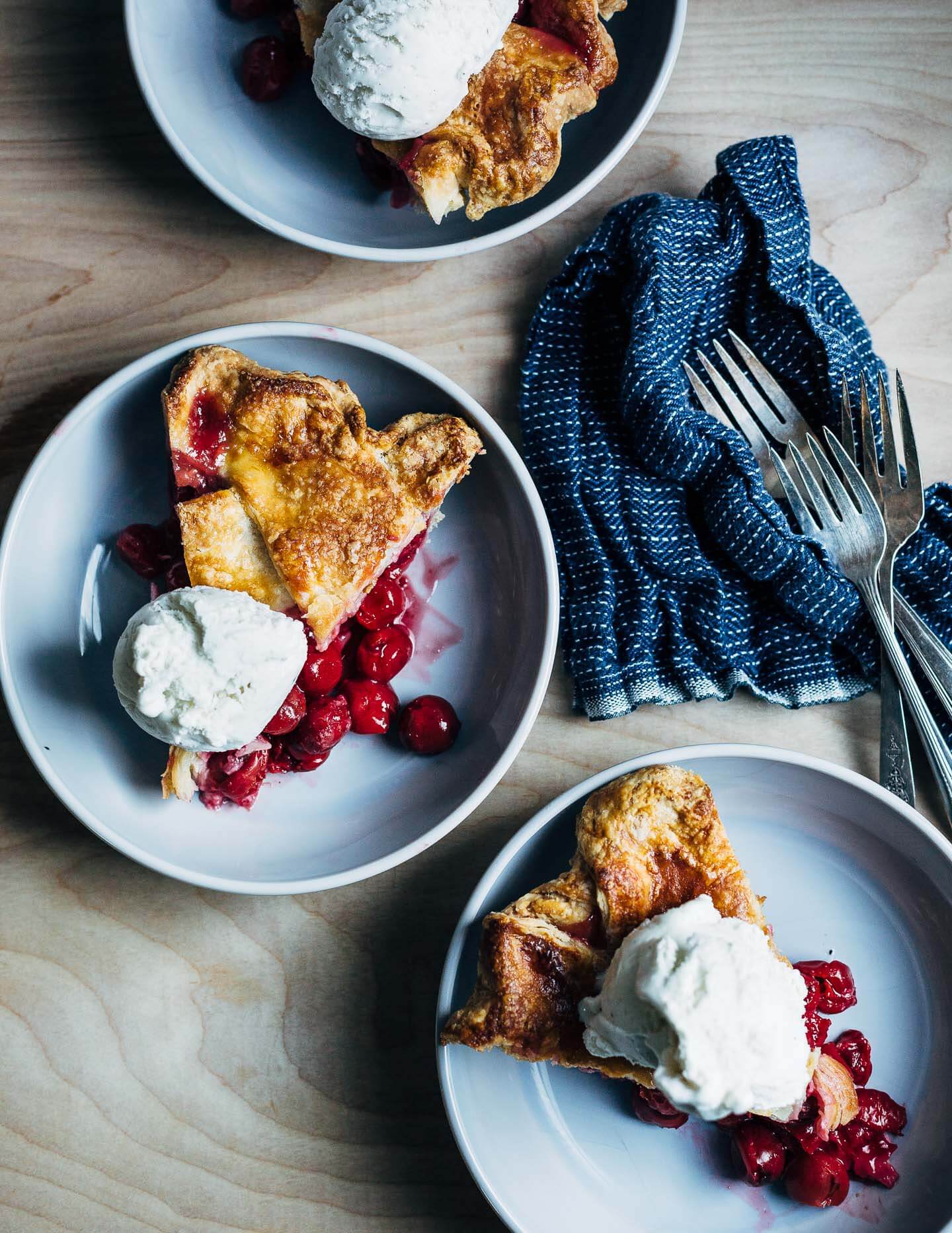 Lattice top sour cherry pie with a flaky, all butter crust, sliced and served a la mode. 