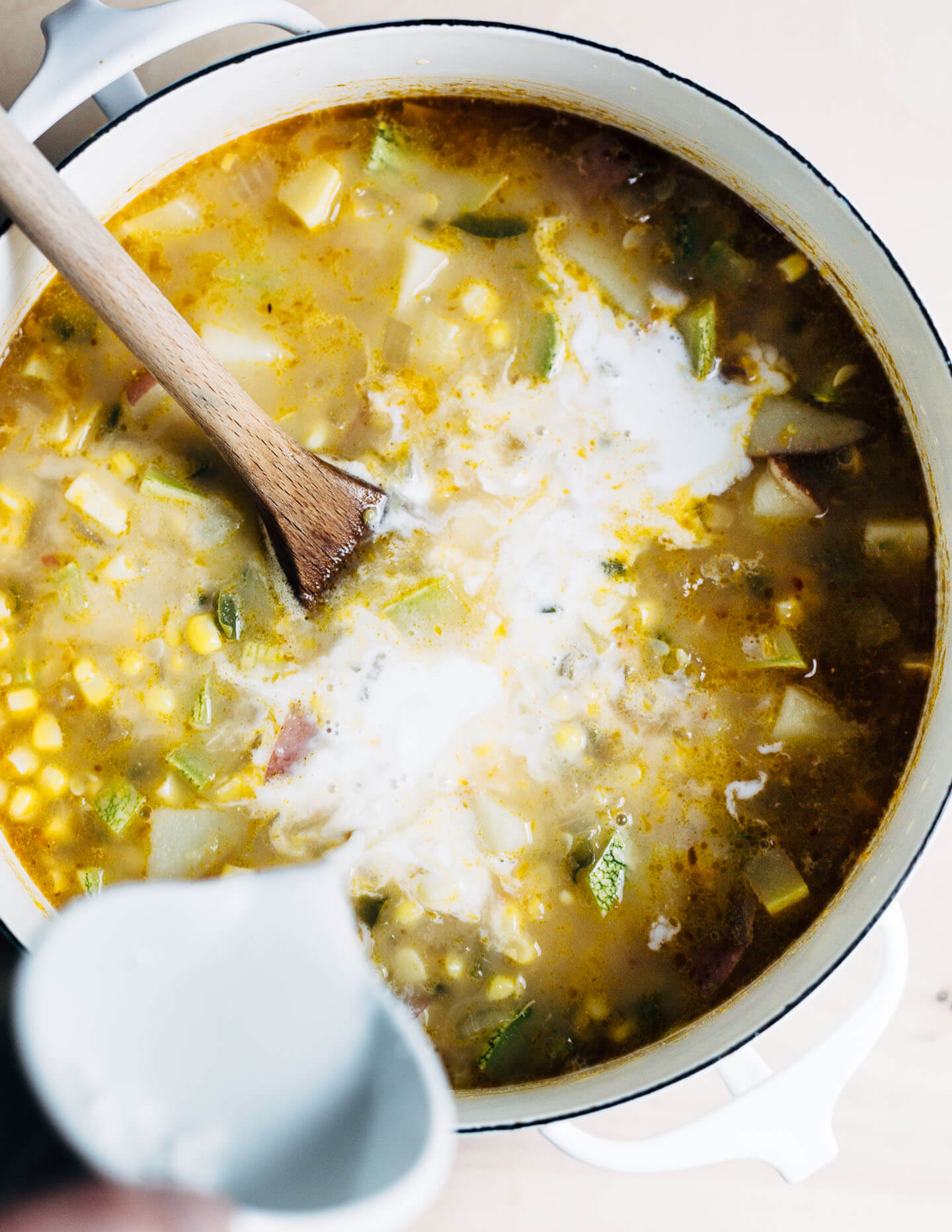 Adding the coconut milk to the corn chowder.