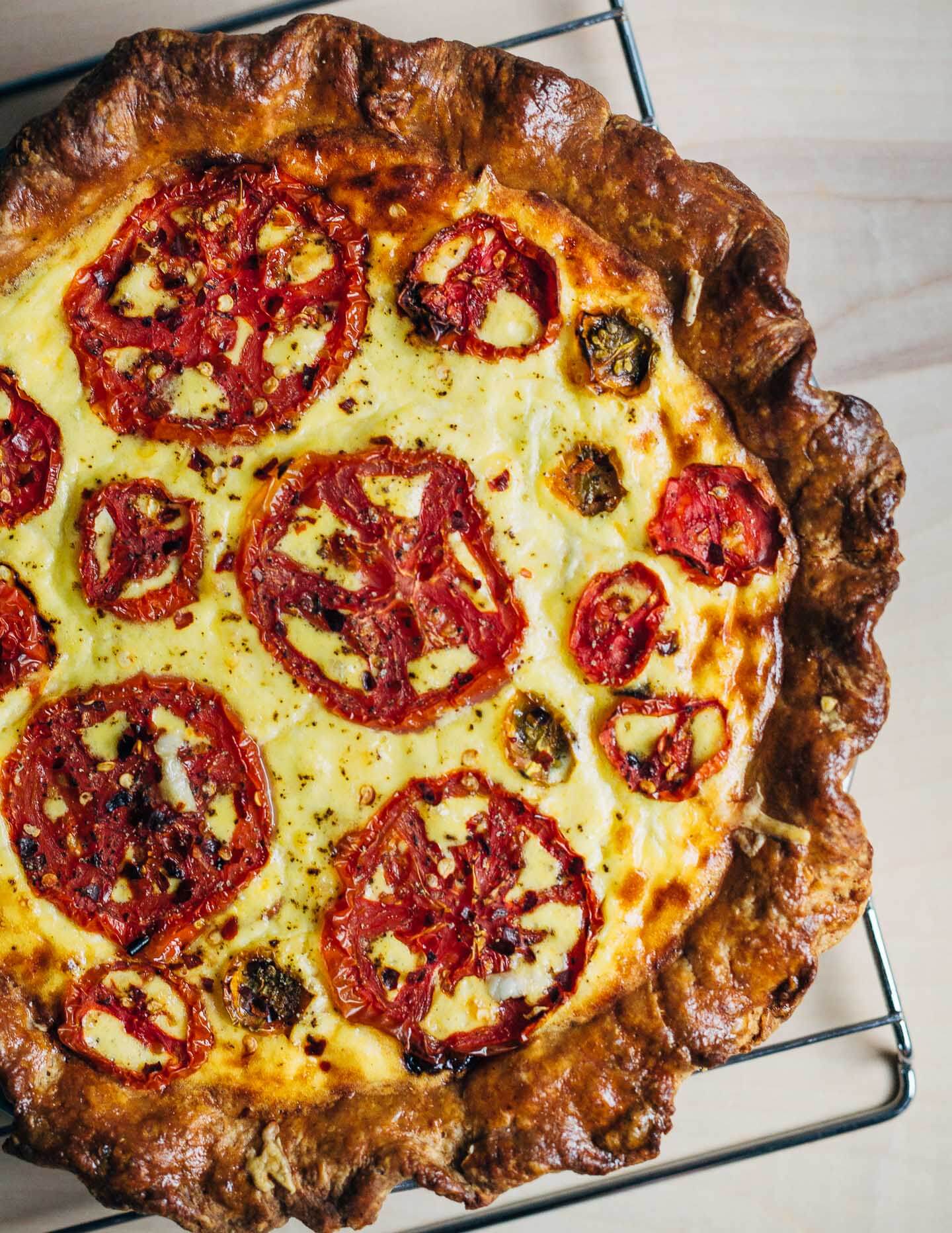 A deeply savory tomato pie that harnesses the acidic, faintly sweet edge of perfectly ripe summer tomatoes. There’s also a flaky whole wheat crust, eggs with bright orange yolks, and handfuls of sharp cheddar. 
