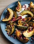 Sweet and savory roasted acorn squash wedges tossed with brown sugar, spicy paprika, black pepper, and fresh thyme. The squash is served with a dollop of crème fraîche, toasted squash seeds, and pomegranate arils.
