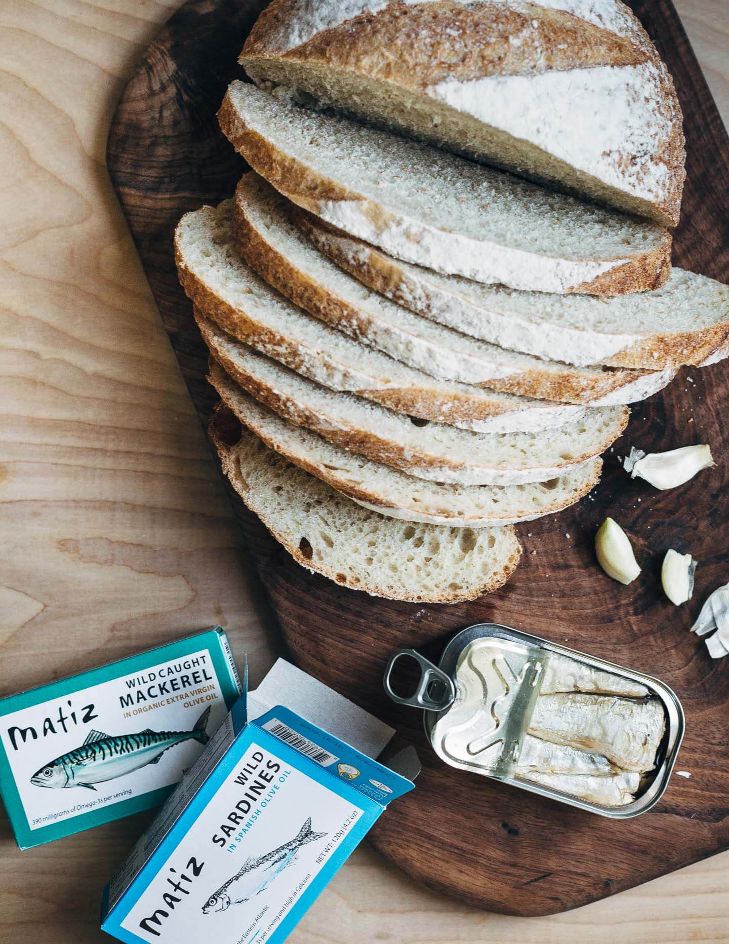 Sliced sourdough, tinned sardines, and garlic. 