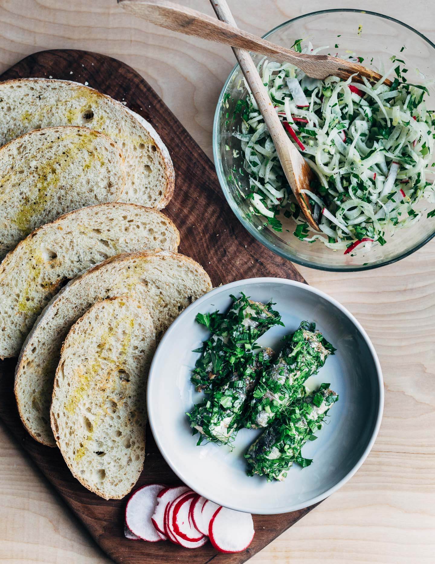 All the fixings for herbed sardine toasts: garlicky sourdough, fennel salad, and tinned sardines tossed with fresh herbs. 