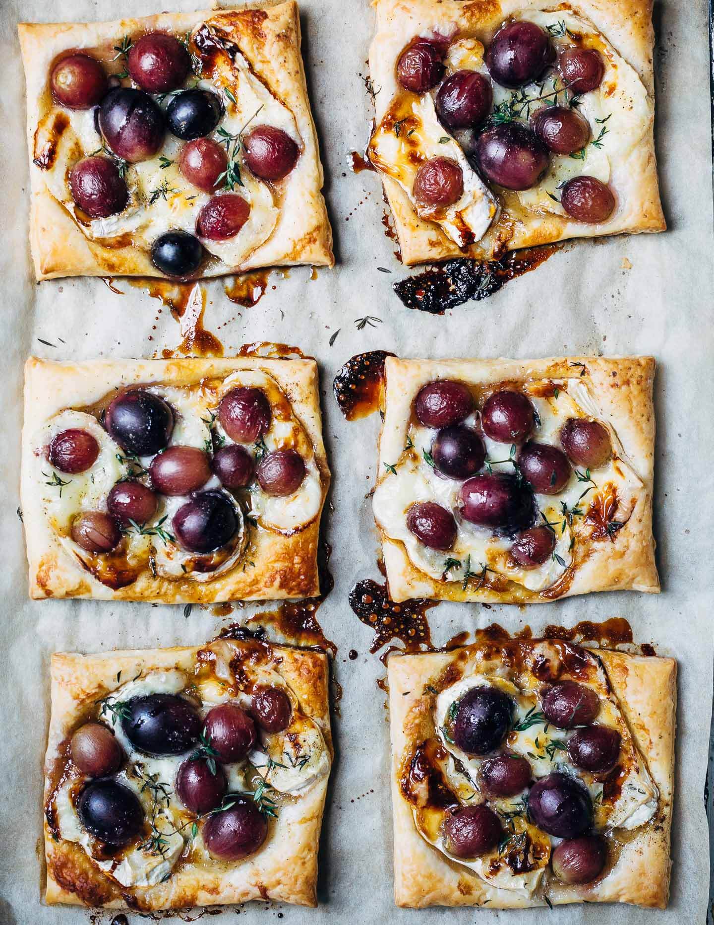 Sweet and savory brie and roasted grape tarts with a drizzle of honey, fresh thyme, and black pepper are the perfect simple-yet-decadent holiday appetizer.