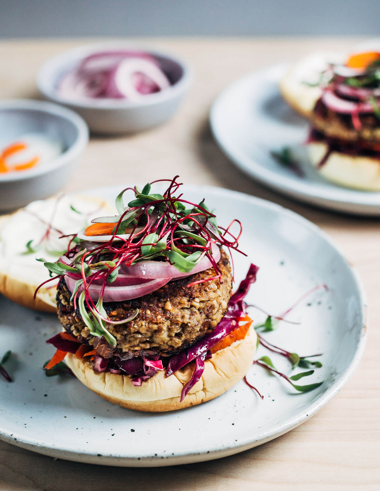 Tahini veggie burgers topped with quick pickles and microgreens. 