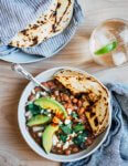 These brothy pinto beans with roasted poblano peppers are wonderfully creamy and rich. They can be made on the stove top or in an Instant Pot, and are served with crumbled Cotija, cilantro, and sliced avocado.