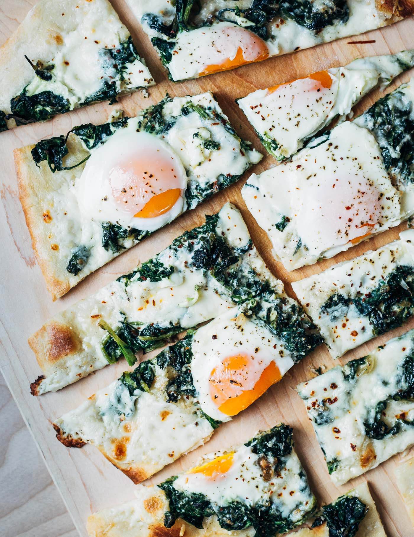 Vibrant greens, just-set eggs, and creamy mozzarella atop a thin but chewy pizza crust make this egg and greens pizza the perfect early spring recipe.