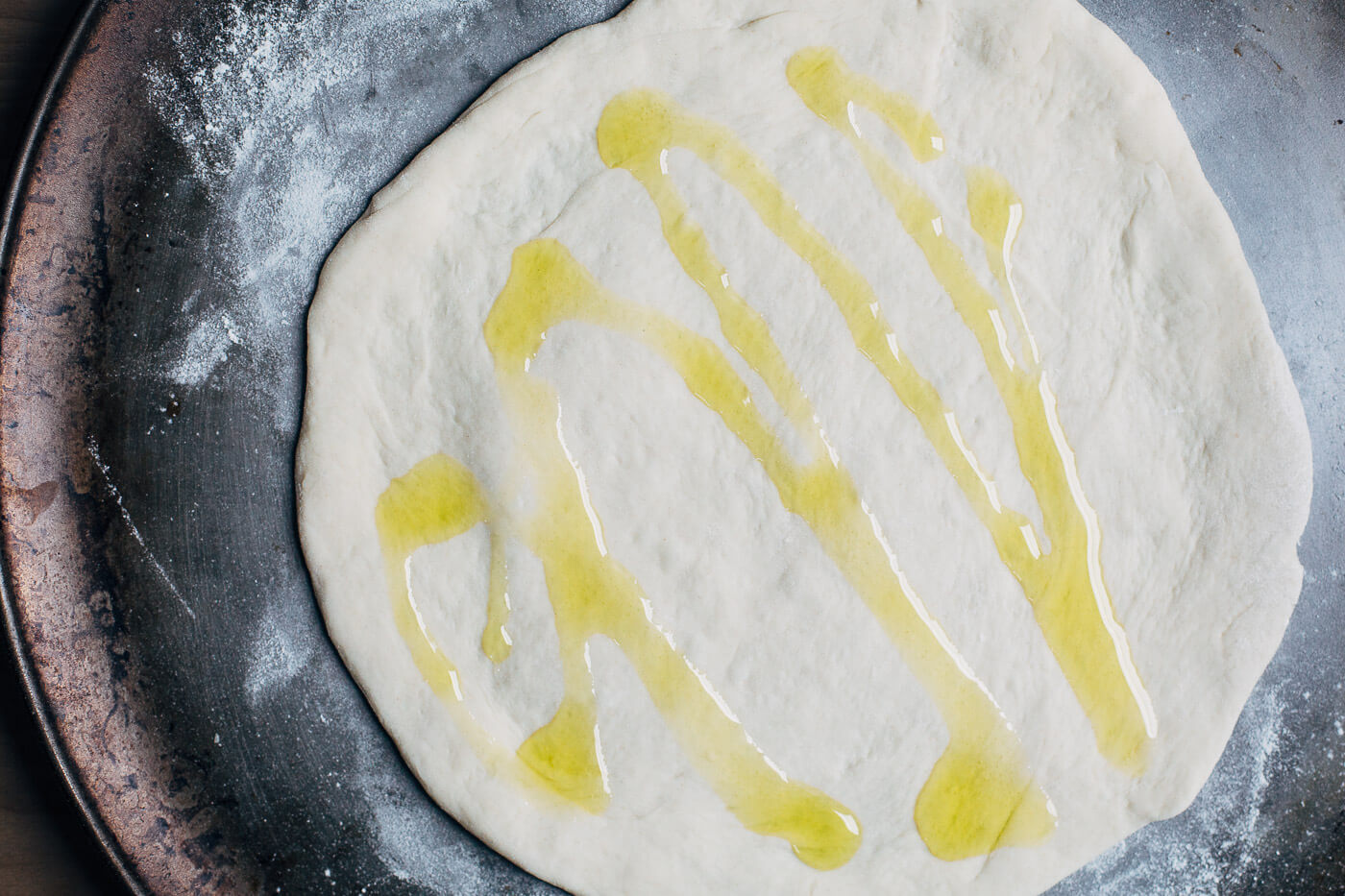 Pizza dough with a drizzle of olive oil.