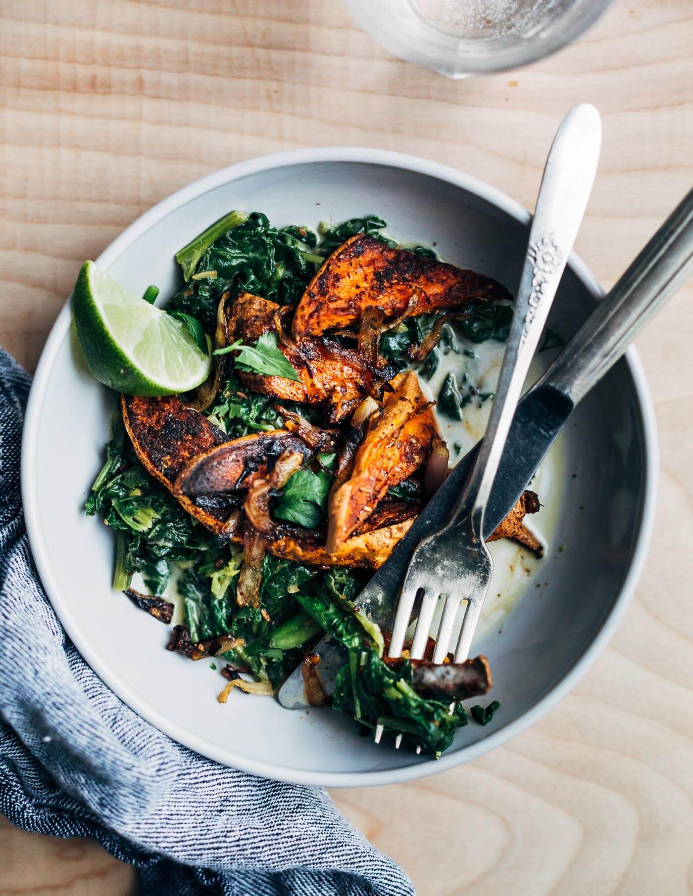 A simple approach to meltingly delicious cooked greens featuring spiced roasted sweet potato wedges and tender coconut milk braised greens with just a bit of heat.