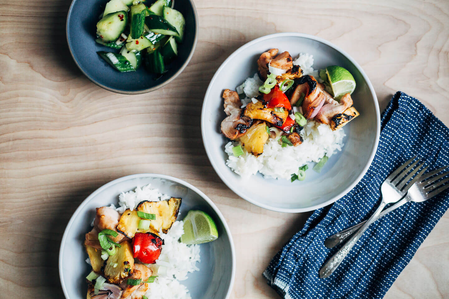 Grilled pineapple chicken served with sticky rice and pickled cucumbers. 