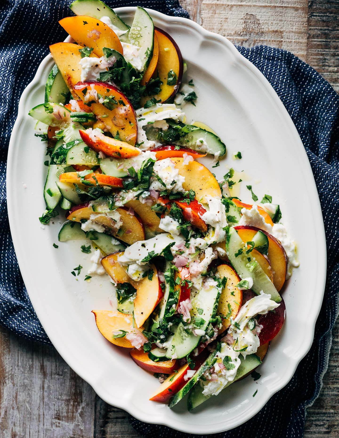 A refreshing savory nectarine and cucumber salad with burrata, green chilies, lemon, and fresh cilantro.