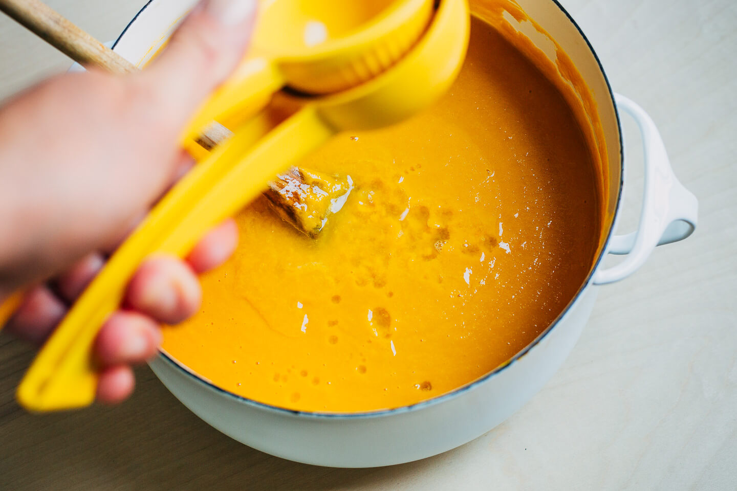 Adding lemon to pureed Honeynut squash and apple soup.