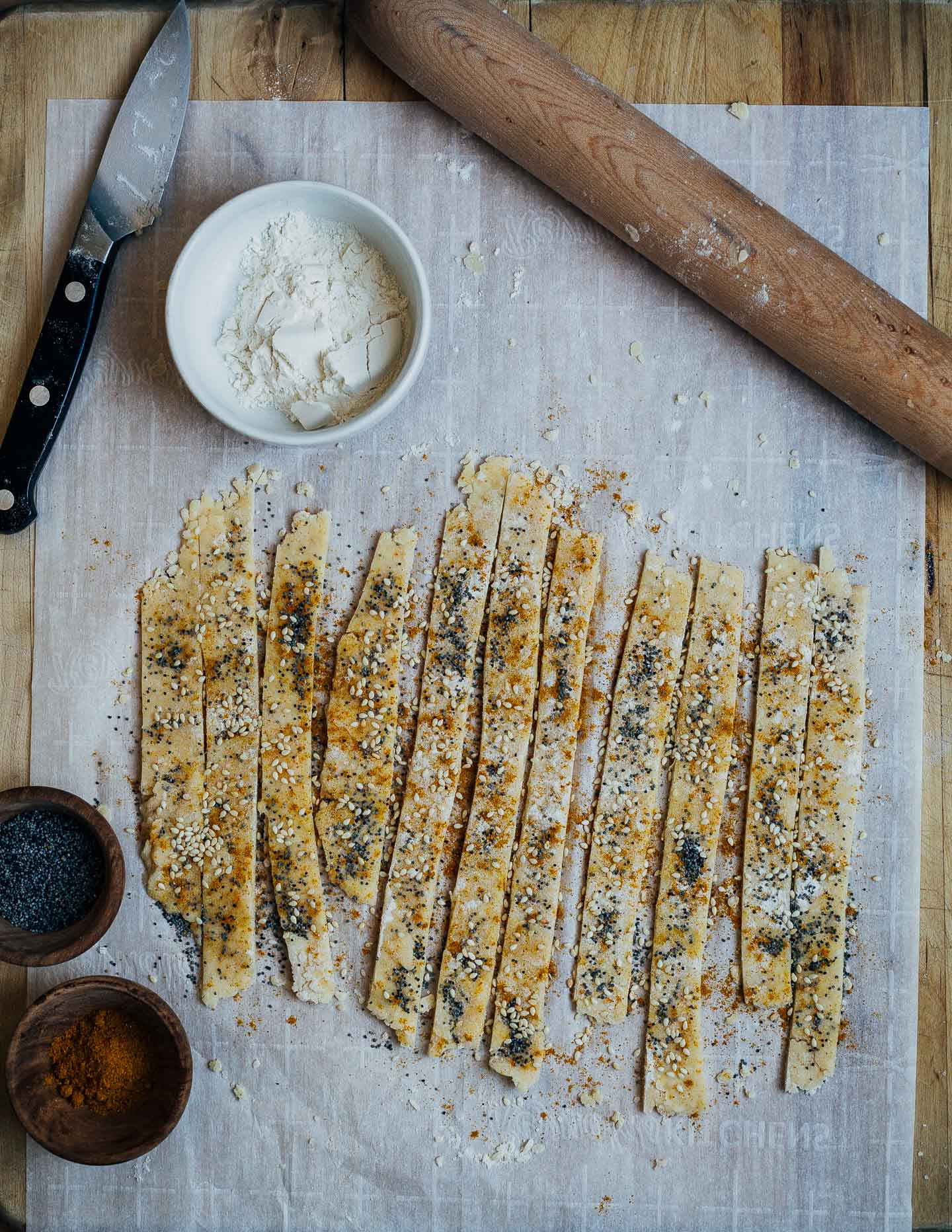 Cutting sesame and poppy seed cheese straws with curry powder. 