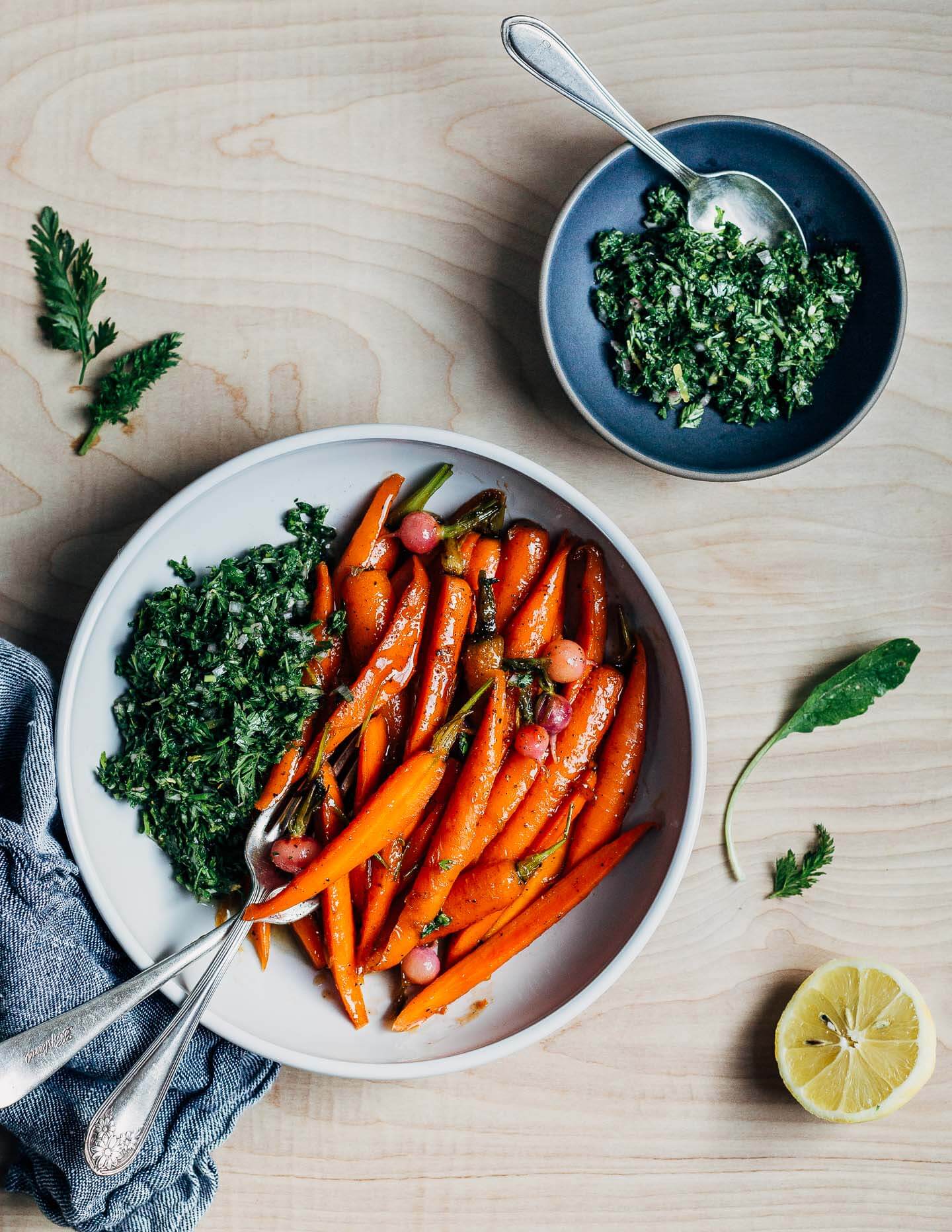 These springy glazed carrots are delightfully buttery and light with a vegetable broth-based glaze and are served alongside a bright carrot top chimichurri.